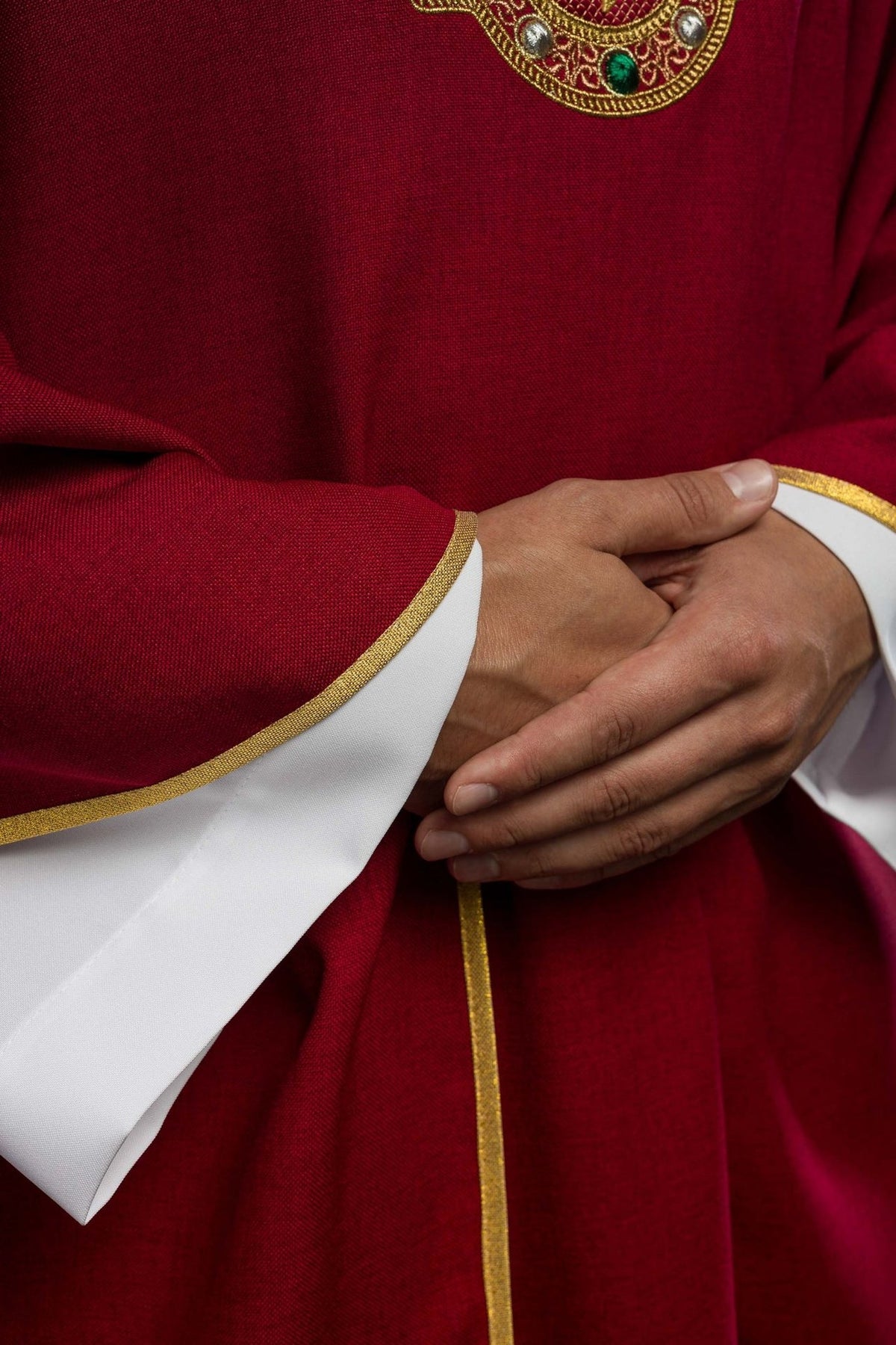 Red chasuble, close-up of gold-trimmed sleeve and red fabric
