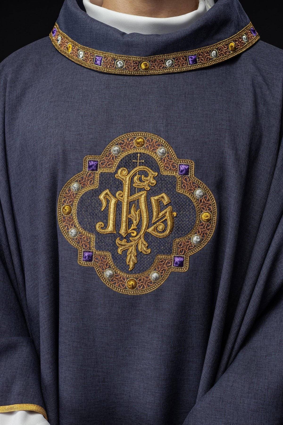 Purple chasuble close-up showing collar trim and IHS embroidery