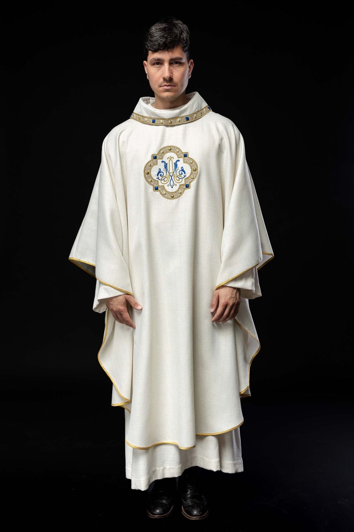White liturgical chasuble front view with embroidered Marian emblem and gold trim