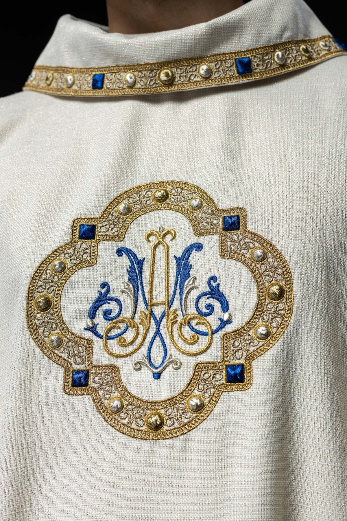 Liturgical chasuble close-up of white collar with gold galloon and blue accents