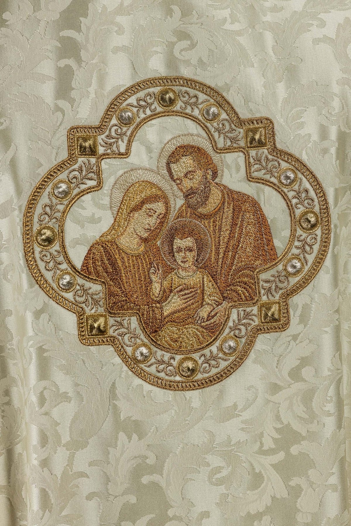 Holy Family embroidery on the chasuble, detailed close-up with gold and brown stitching