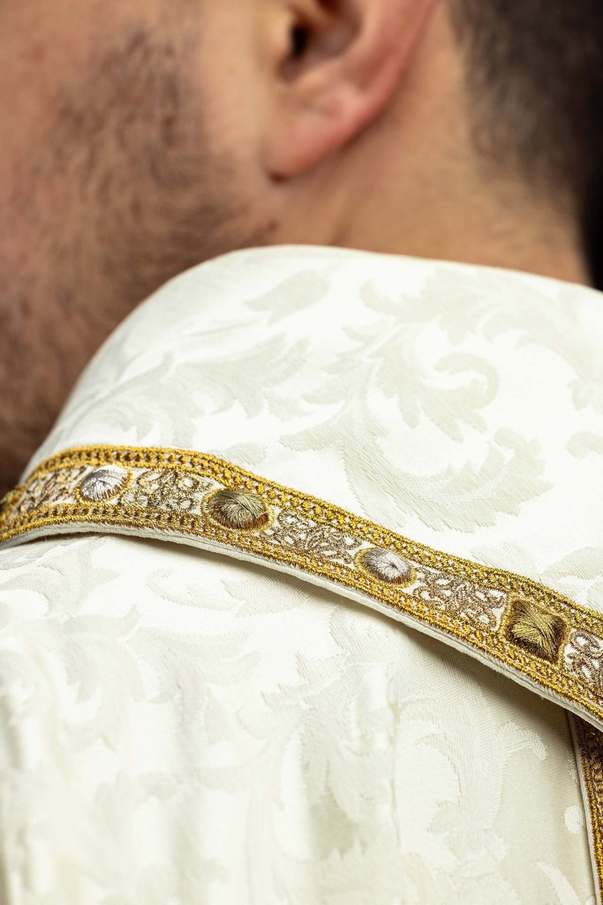 Side close-up of Paschal Lamb embroidery and gold orphrey on the chasuble