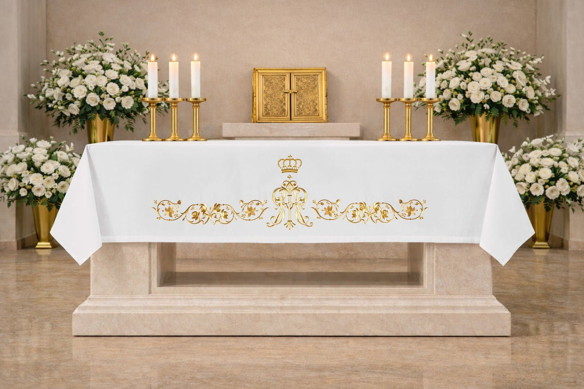 White altar cloth front view with centered gold Marian symbol and floral embroidery