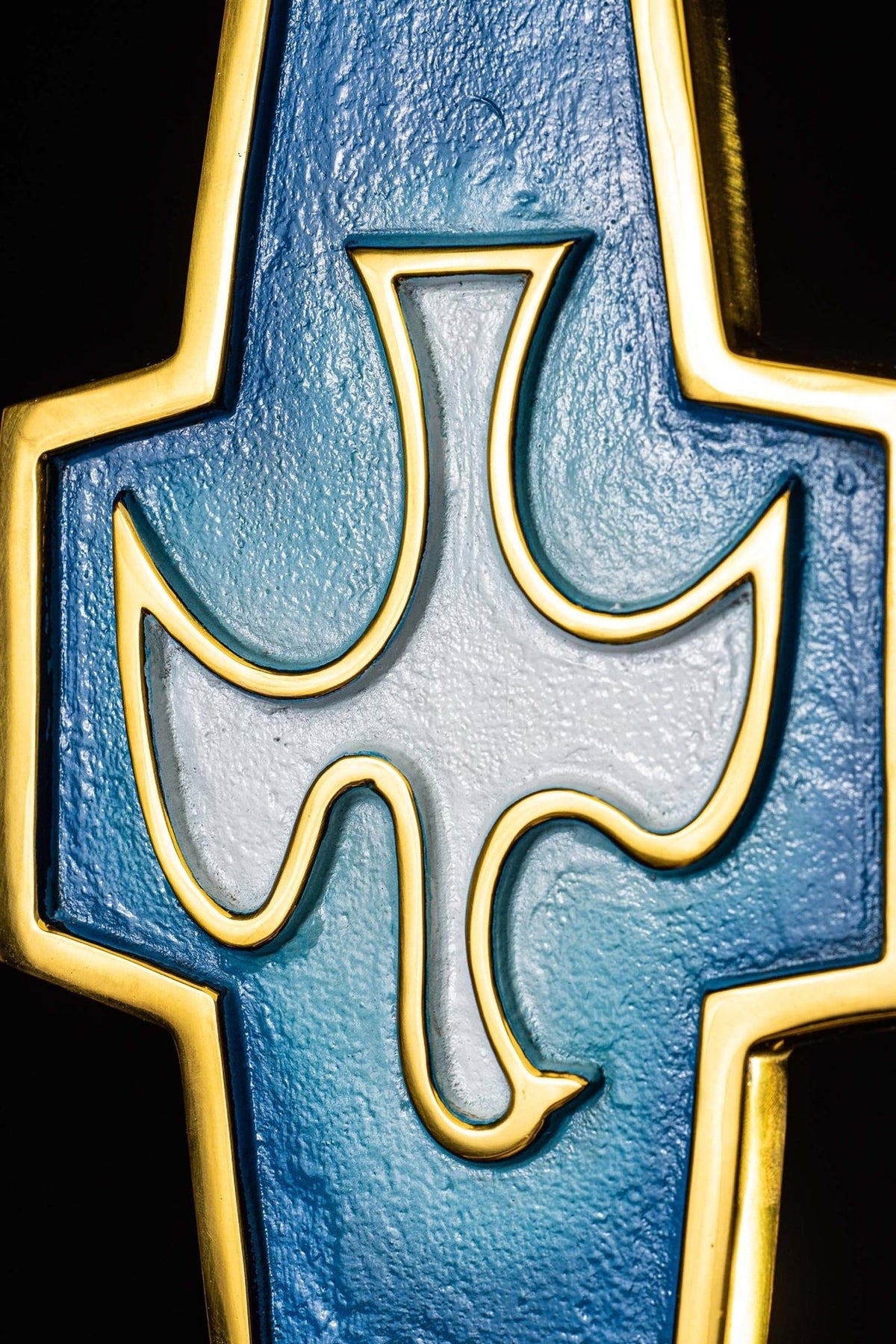 Holy water font close-up showing the blue and gold Holy Spirit symbol