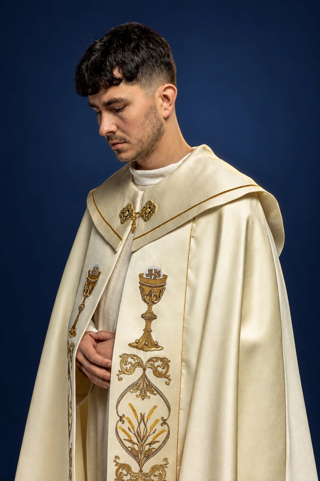 Three-quarter front view of an ecru cope with central chalice and floral gold embroidery, worn over the shoulders